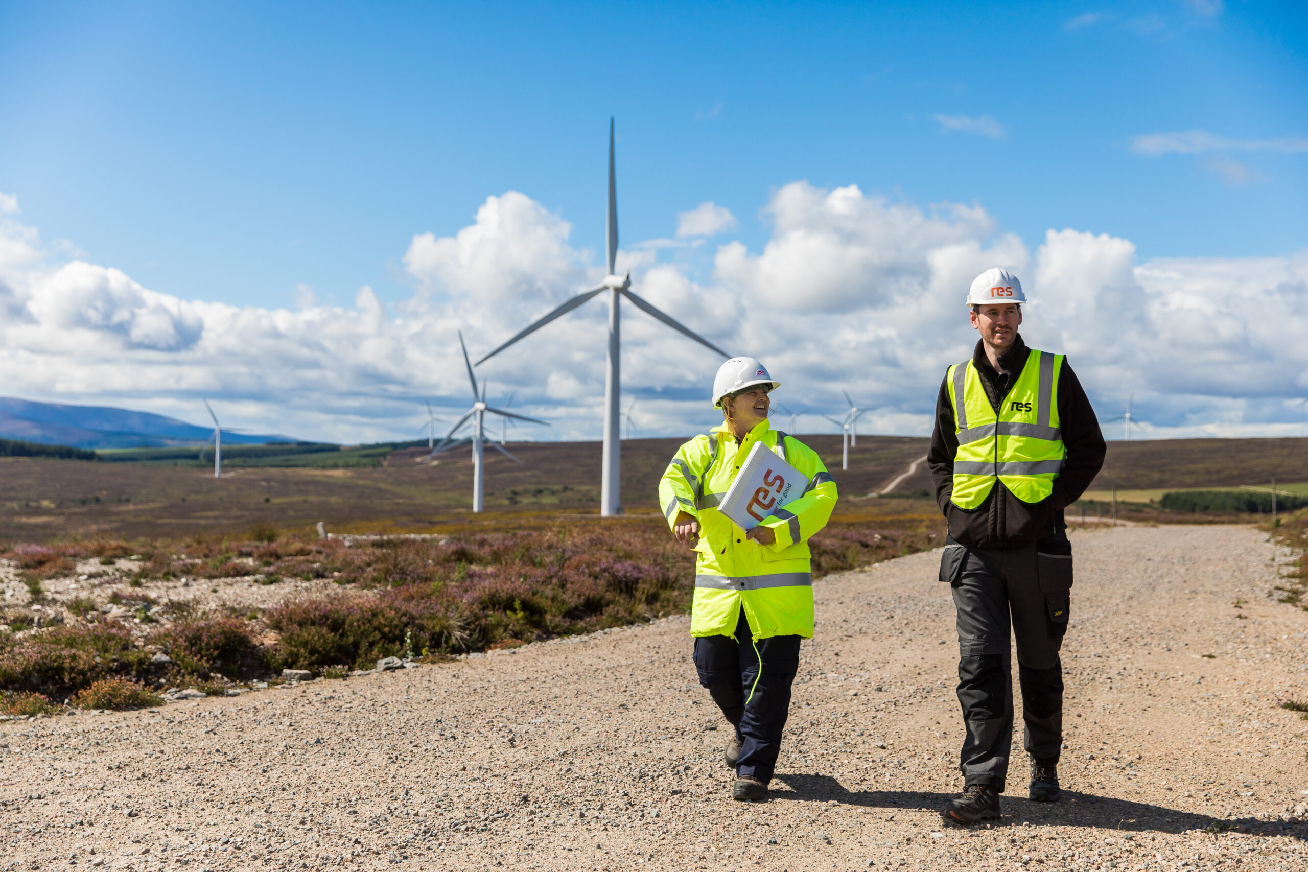 People talking in front of wind turbines